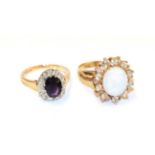 A 9 carat gold amethyst and diamond cluster ring, the oval cut amethyst within a border of eight-cut