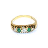 An 18 carat gold emerald and diamond five stone ring, three round brilliant cut diamonds alternate