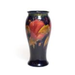 A William Moorcroft Pomegranate vase, on a blue ground, impressed marks and green painted signature,