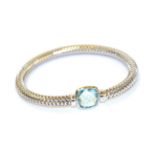 A blue topaz bangle, the white expanding snake link bangle with a fancy cut blue topaz centrally, in