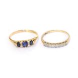 An 18 carat gold synthetic sapphire and diamond ring, three graduated oval sapphires spaced by trios