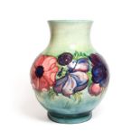 A Walter Moorcroft Anemone pattern vase, on a blue wash ground, blue painted monogram and