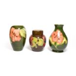 Two Walter Moorcroft Coral Hibiscus pattern vases, on green grounds, impressed factory marks, 18.5cm