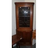 An early 19th century oak double corner cupboard