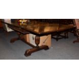 A 1920s oak drawer-leaf dining table with trestle base