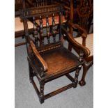 A 19th century provincial carved and inlaid oak plank seated open armchair