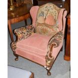 A 1920's carved oak framed needlework upholstered wing-chair