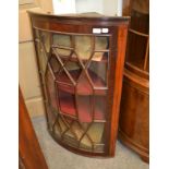 A George III mahogany bow-fronted handing corner cupboard