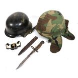 A Post War German Helmet, later painted black, with folded brim,