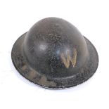 A British Second World War Brodie Helmet, the black painted steel skull painted W in white (Warden),