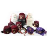 A Collection of Eight Shriners International Fezzes, six in crimson felt and two in cream felt,