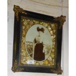Victorian ornate photo frame with abalone shell border and brass corners flanking a sepia photograph