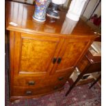 Mahogany and burr walnut bow fronted two door cupboard over two drawers