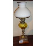 Small Victorian brass oil lamp with glass reservoir above brass column having copper filigree