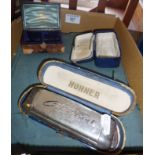 Album of old postcards and a Hohner Chromica 1 deluxe mouth organ