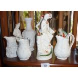 Two bisque Portmeirion jugs, a similar and three figures
