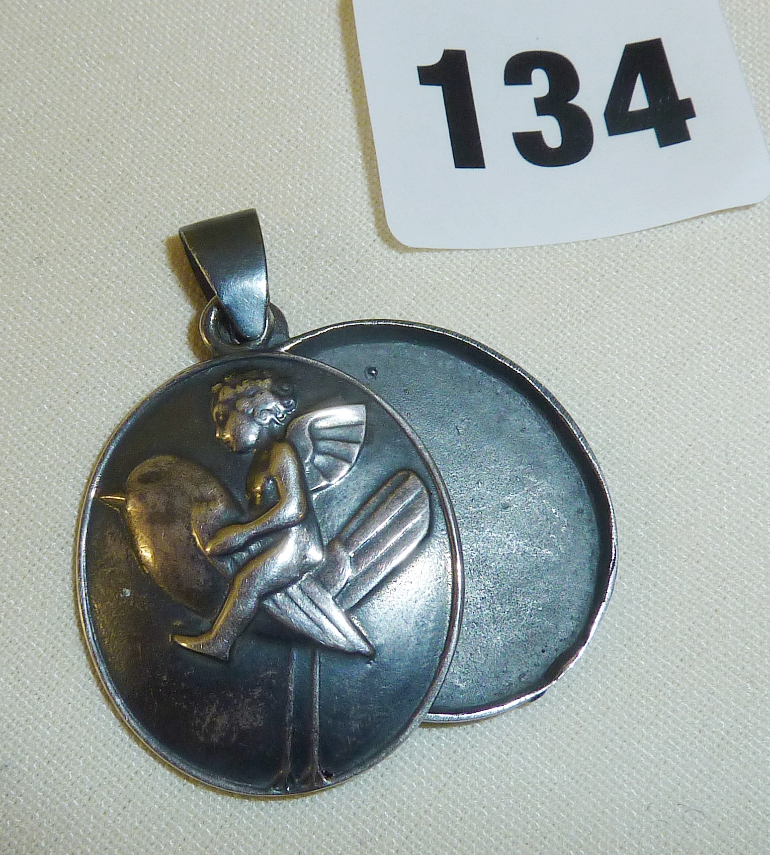 An Art Deco style Weiner Werkstatte silver double locket depicting a fairy riding a sparrow -