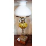 Small Victorian brass oil lamp with glass reservoir above brass column having copper filigree