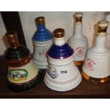 Five Wade china decanters full of Bell's Whisky