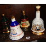 Four Wade china decanters full of Bell's Whisky