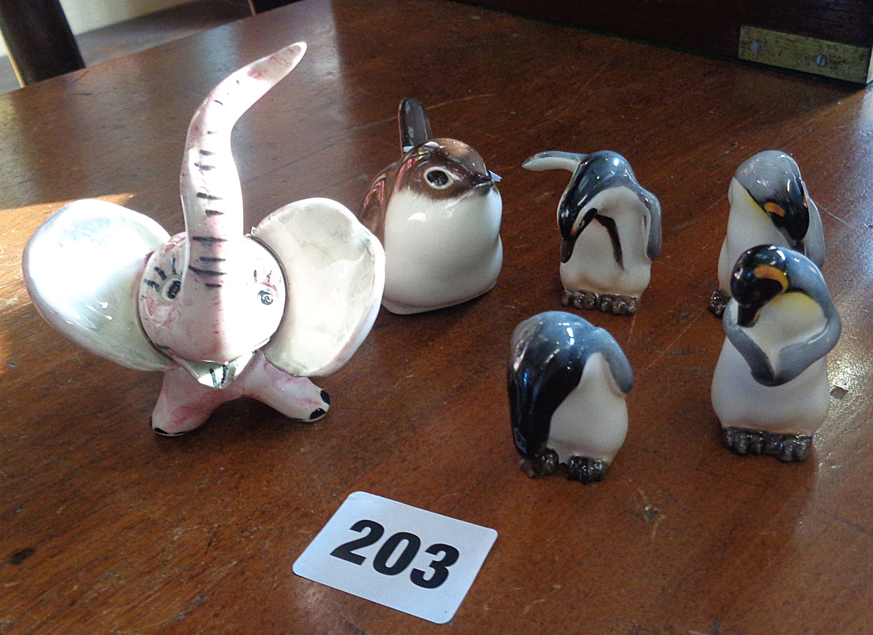Four Royal Doulton penguins, and two other miniature china figures