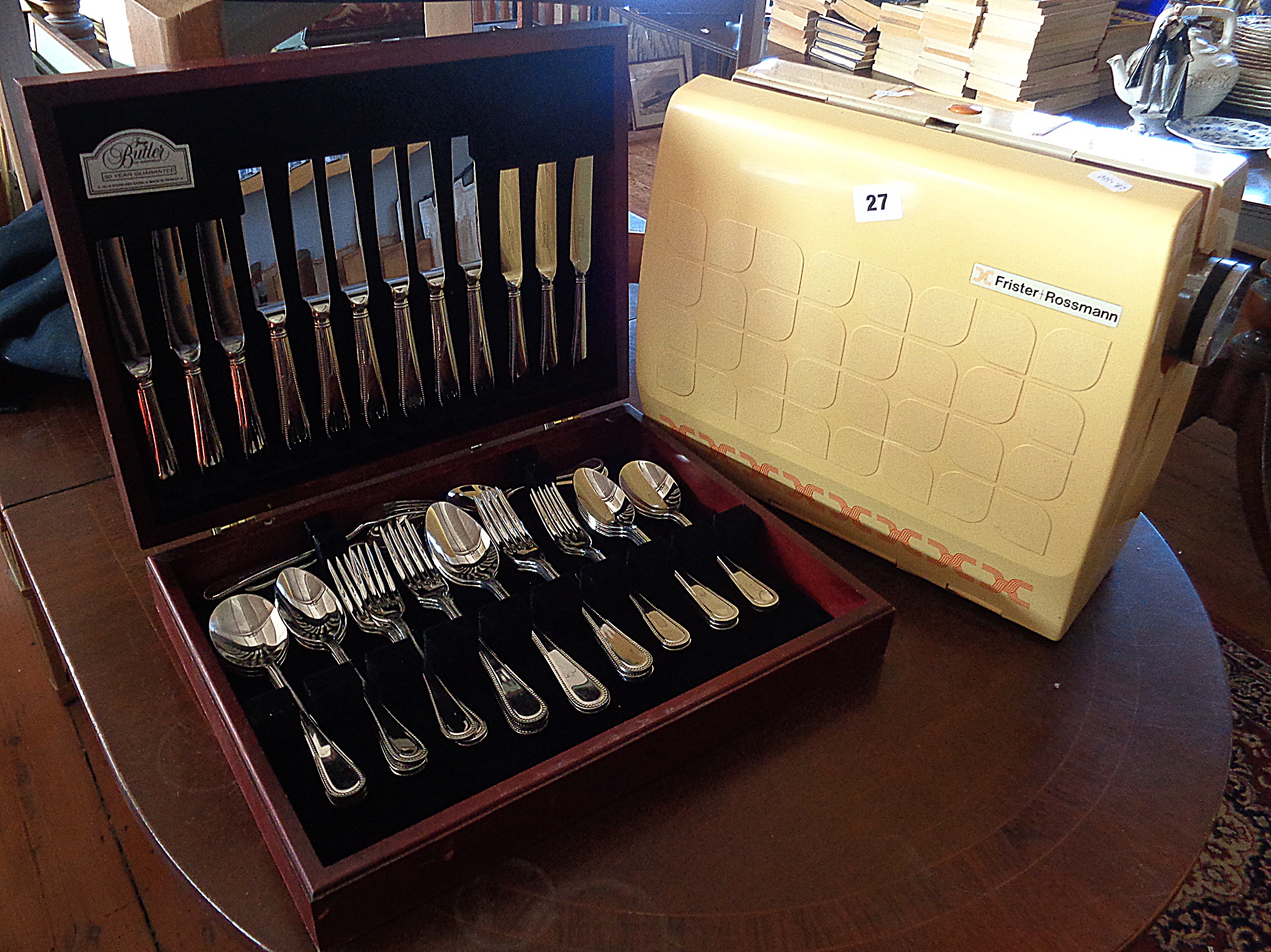 A Frister & Rossmann 'Cub 7' sewing machine and a canteen of cutlery