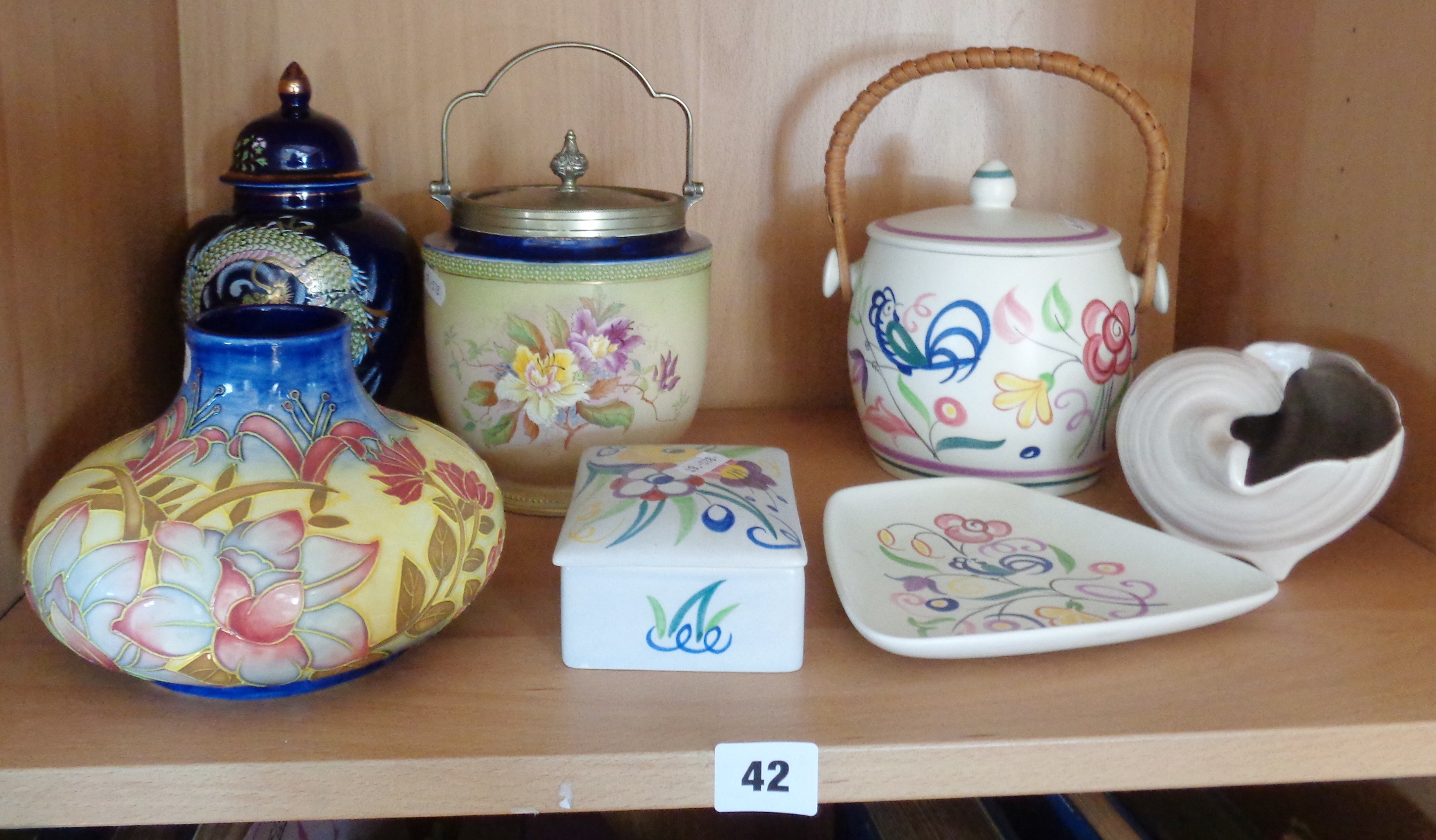 Four pieces of Poole Pottery, inc. biscuit barrel and three others