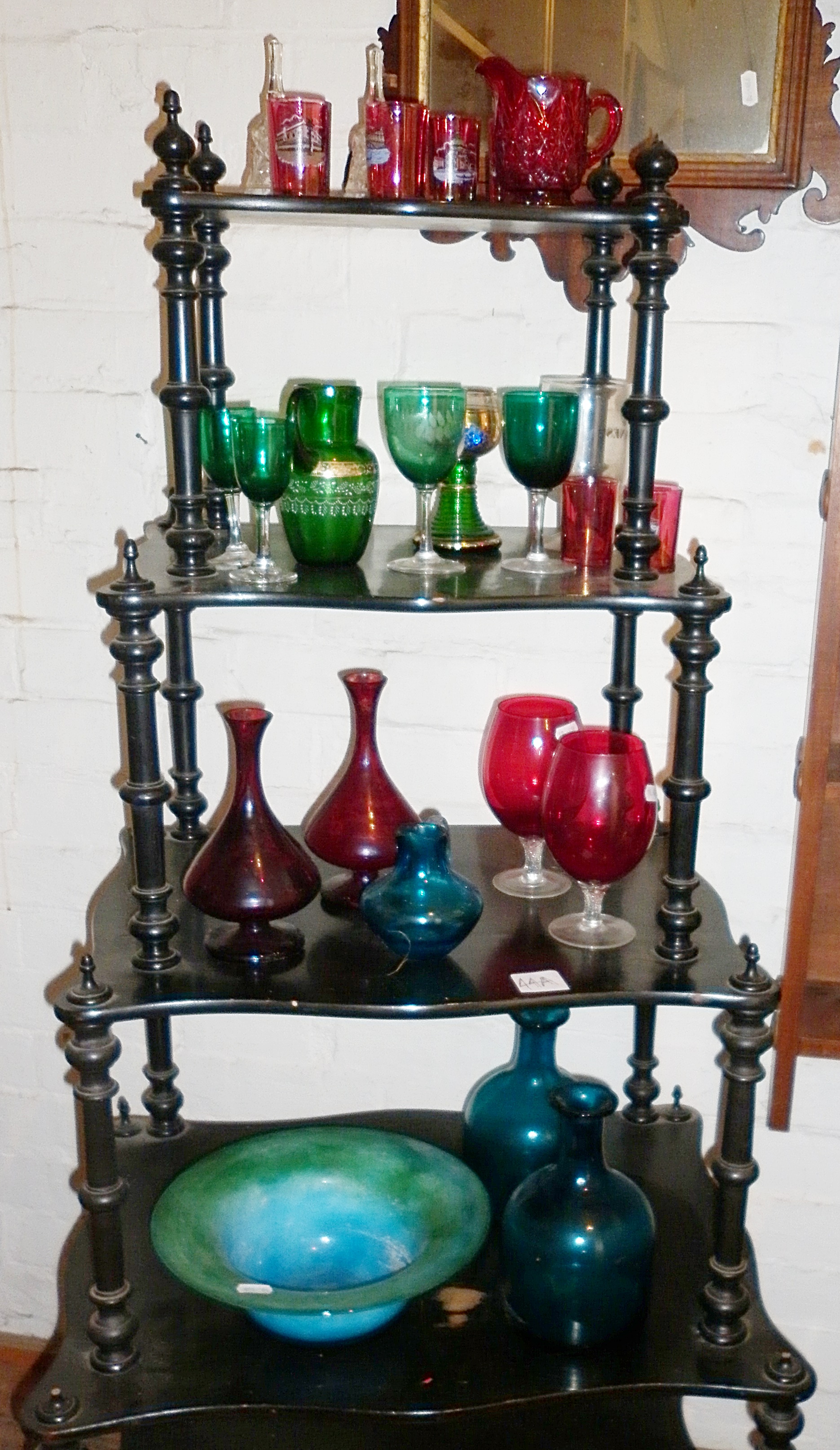 A collection of cranberry wine glasses, green glasses and a striated glass fruit bowl with two