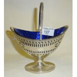 Georgian silver boat shaped sugar basket with swing handle and blue glass liner. In the Adams