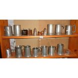 Two shelves of assorted pewter tankards