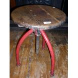 Industrial machinist's swivel stool with red painted metal tripod legs