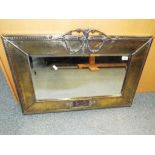 A very heavy good quality vintage bevel edged wall mirror with hammered brass frame displaying a