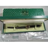 Gucci - a lady's designer Gucci Swiss made wristwatch with leather strap black Gucci face with