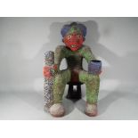 An African Bamileke, Cameroon, beadwork figure depicting a seated male holding a cup and staff,