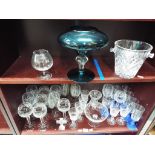Two shelves containing a quantity of predominantly drinking glasses in sets, a centrepiece,