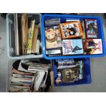 Four boxes containing a large quantity of DVDs, single vinyl records,