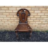 An oak hall chair with carved decoration.