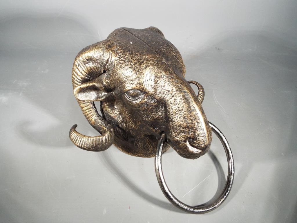 A cast iron ram's head door knocker measuring approximately 15 cm (h),