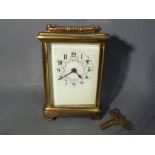 A French brass and glass carriage clock, Arabic numerals to the dial, with key.