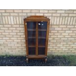 A glazed bookcase / display cabinet measuring approximately 130 cm x 60 cm x 31 cm.