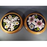 Moorcroft - two Moorcroft Pottery framed plaques decorated in the Pure Innocence pattern on a blue