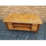 A pine coffee table having eight drawers, measuring approximately 53 cm x 109 cm x 56 cm.