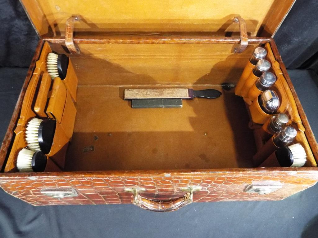 An early 20th century crocodile travelling dressing case by the North West Tanner and Co Limited