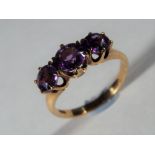 14 ct - a Lady's 14 carat yellow gold trilogy ring set with amethyst,