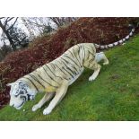 A life size model of a crouching tiger, approximately 70 cm (h) and 230 cm (l),