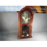 A contemporary mahogany cased, wall clock with mechanical movement, with pendulum and weights,