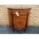 An ealy demi-lune cabinet with extensive inlaid foliate and scrolled decoration,