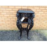 An early period ebonized hall table / plant stand intricately carved with supports in the style of