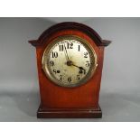 A mahogany cased mantel clock, Arabic numerals to the dial, with key and pendulum.