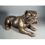 A cast iron bulldog in a lying position